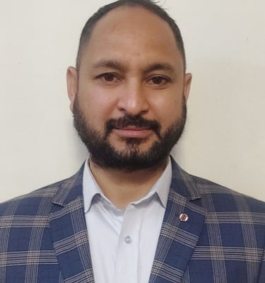 A bearded man in a blue jacket, a Principal and ex-service man, well qualified and knowledgeable.