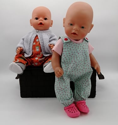 two Baby Born brand dolls dressed in handmade clothing