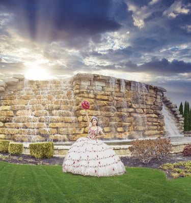 a woman in a white quinceanera dress standing in front of a fountain