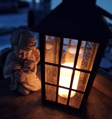 glowing candle lantern on porch with angel.