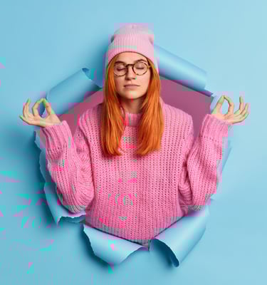 a woman in a pink sweater and glasses is looking at the camera