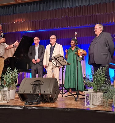 a group of people standing on a stage with a microphone
