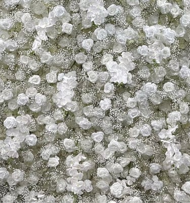 Elegant floral backdrop featuring a dense arrangement of white roses and baby's breath for wedding decor.