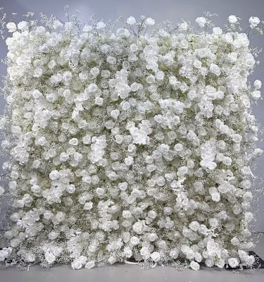 Elegant wedding backdrop featuring a dense wall of white roses and delicate baby's breath flowers.