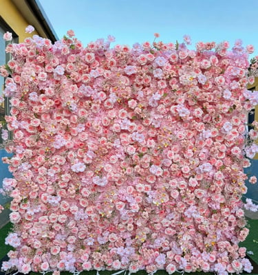 A pink flower wall backdrop featuring artificial roses and cherry blossoms for events.