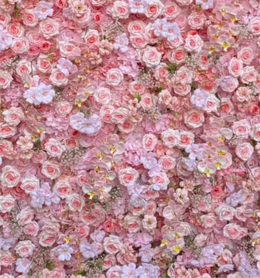 Floral backdrop featuring a dense arrangement of light pink roses and orchids for event decor.