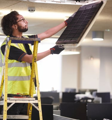 Técnico realizando mantenimiento de aire acondicionado en oficina de Valencia