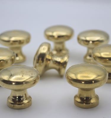 a group of golden knobs on a white table
