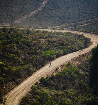 Cyclists riding mountain bikes on gravel road competition after having a cycling coach