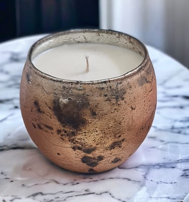 a candle with a candle in a distressed gold glass votive
