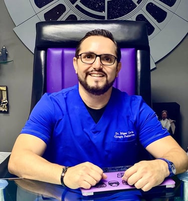 a man in a blue shirt and glasses sitting at a desk