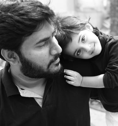 a father and his little child are smiling and hugging