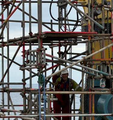 Chartered IOSH consultant James standing on scaffolding on an offshore rig, performing a safety inspection of work at height