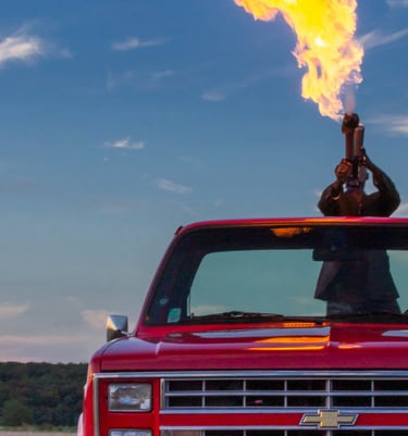 Lance-flamme dans un Pick-up rouge Chevrolet C10 dans un champ