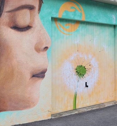 Fresque extérieure peinte, représentant un enfant souflant sur un pissenlit.