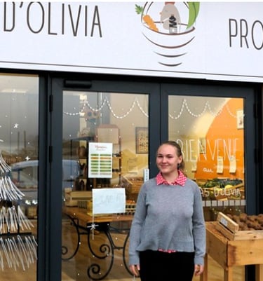 Olivia qui se tient debout devant le magasin Le cabas d'Olivia