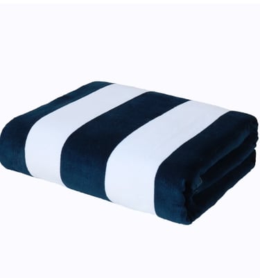 Folded navy blue and white striped plush beach towel made of soft microfiber fabric.