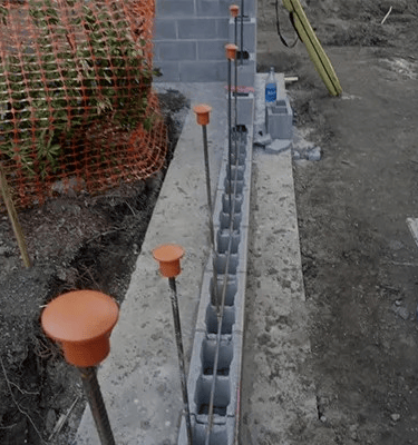 a concrete block structure with orange plastic caps and orange plastic caps