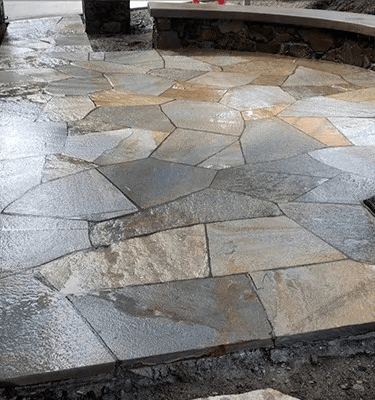a stone patio with a bench and a fire hydrant