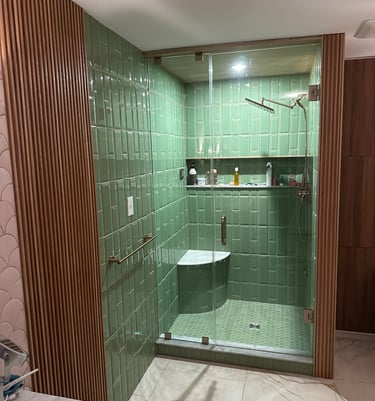 Modern bathroom featuring green subway tiles, wood slat walls, and a glass walk-in shower.
