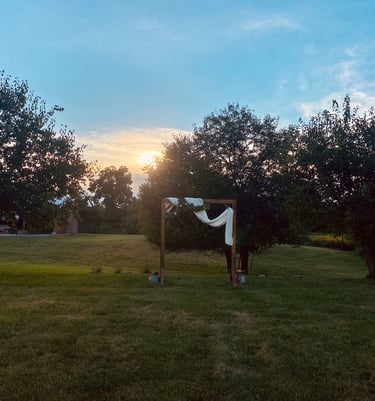 wedding arbor in a meadow at sunset