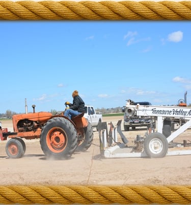 antique tractor pulling a sled