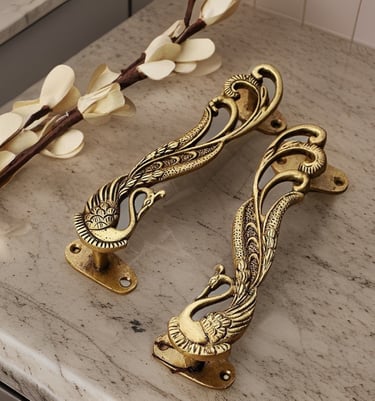 a pair of antique brass - plated handles on a marble counter top