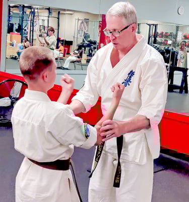 Shihan David Pickthall adjusting a brown belt student during Sanchin kata at Kyokushin Karate USA Rochester NY