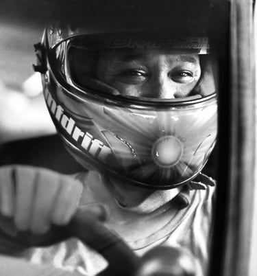 Close-up of a race car driver with a race helmet on inside a car