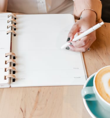 virtual assistant holding a pen and writing on a notebook