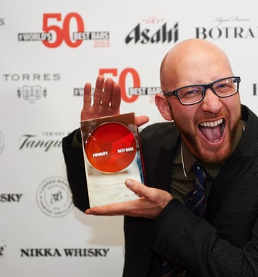 a man with a beard and glasses holding an award, he is very excited about winning