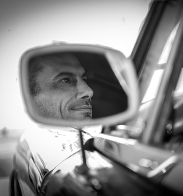 a man in a car mirror and a car mirror