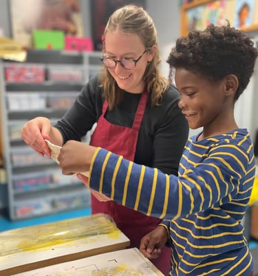 One of our teachers printing with a smiling Benton student.