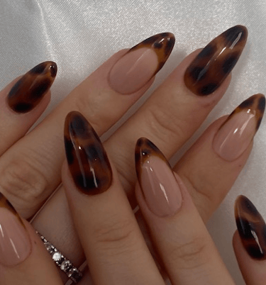 a woman's hand painted nails with a leopard print