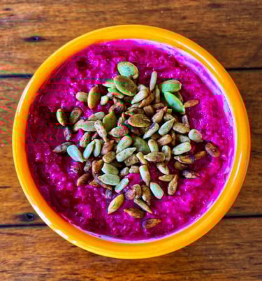 A creamy bowl of huumus topped with crunchy seeds 