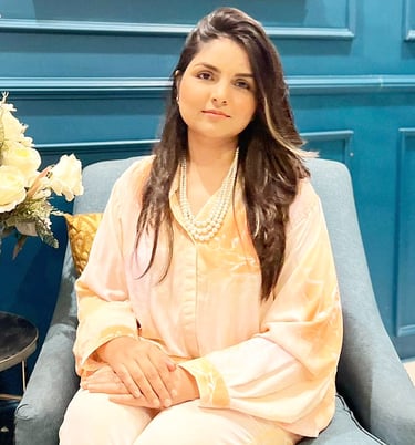 a woman sitting in a chair with a vase of flowers