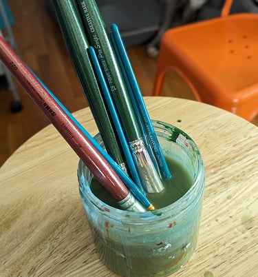 Artist's brushes in an artist's brush water jar.