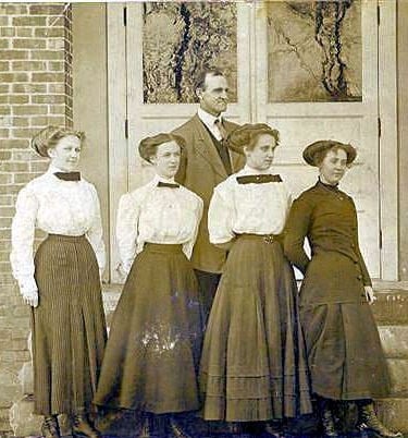 a group of people standing in front of a brick building