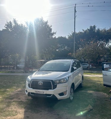 a white toyota fortuner parked in a grassy area