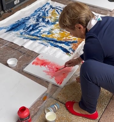 a woman is painting with a paintbrush