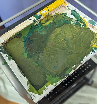An old stretched canvas serving as a painter's pallet.