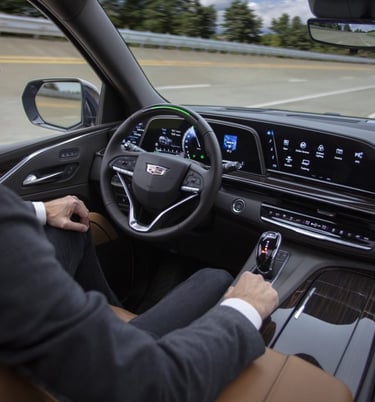 a man in a suit and tie is driving a car