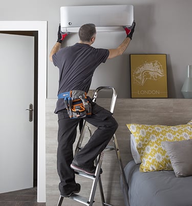 a man is standing on a ladder to reach a window