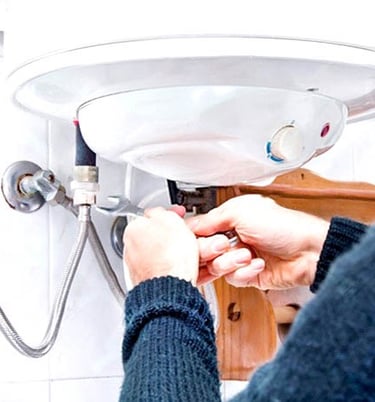 a woman in a blue sweater is fixing a sink