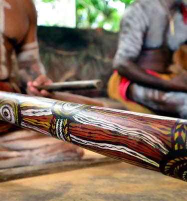 two men one player a didgeridoo the other playing clapsticks