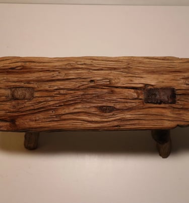 Rustic reclaimed wood bench featuring a weathered natural grain texture and sturdy timber legs.