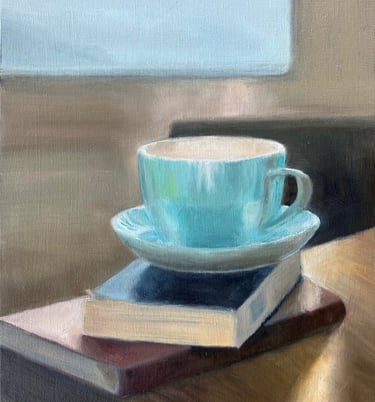 An original oil painting of cup and saucer on books in front of a sunlit window