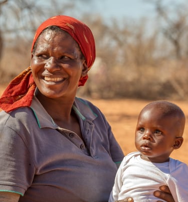 a woman in a red shirt and a baby in a red hat
