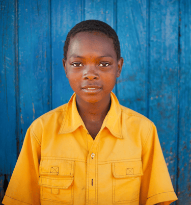 a young boy in a yellow shirt and a blue background