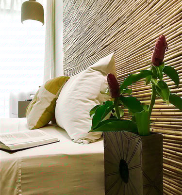a vase with a flower in a vase on a bed